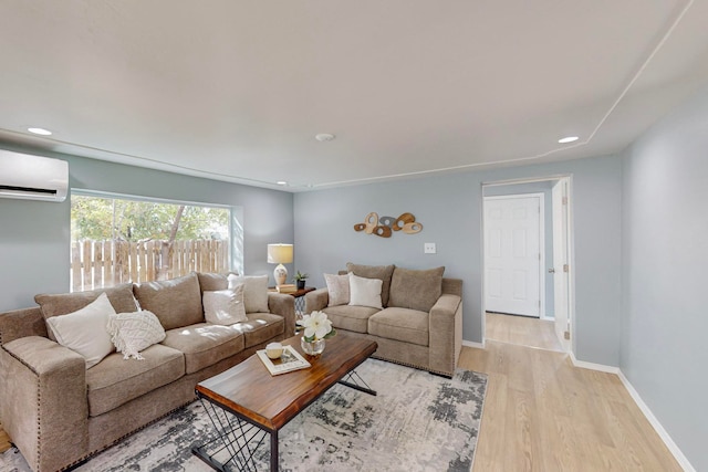 living room featuring light hardwood / wood-style floors and an AC wall unit