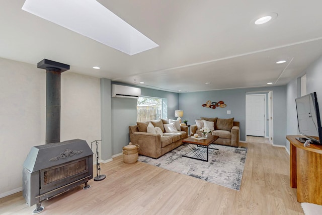 living room with a wall mounted air conditioner, a wood stove, and light wood-type flooring