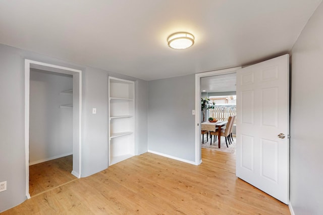 interior space with light hardwood / wood-style flooring, a closet, and a walk in closet