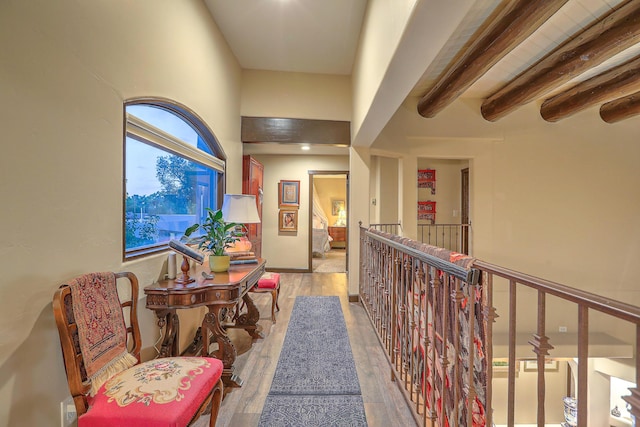 hall with hardwood / wood-style floors and beam ceiling