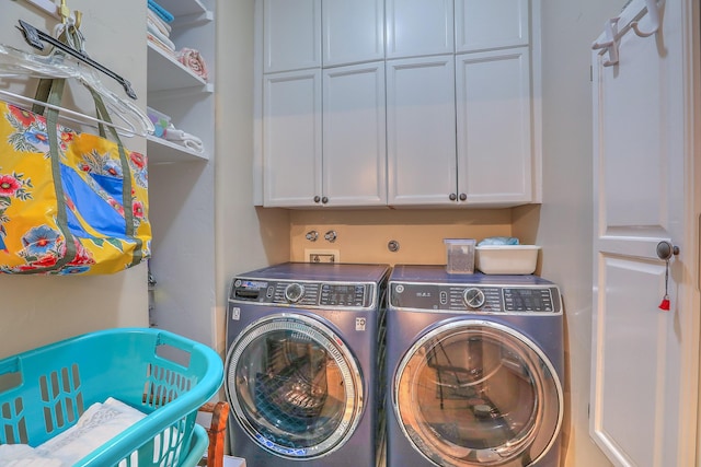 washroom featuring cabinets and separate washer and dryer