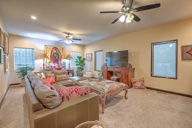 carpeted living room with a wealth of natural light and ceiling fan