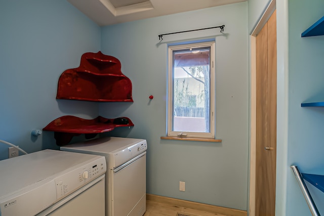 laundry room with light wood-type flooring and independent washer and dryer