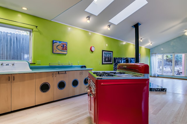 game room with vaulted ceiling with skylight, ceiling fan, light hardwood / wood-style floors, and sink