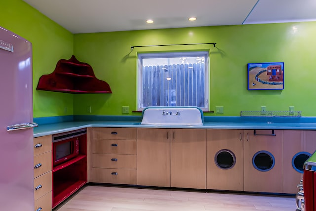 kitchen with built in microwave, sink, refrigerator, and light hardwood / wood-style floors