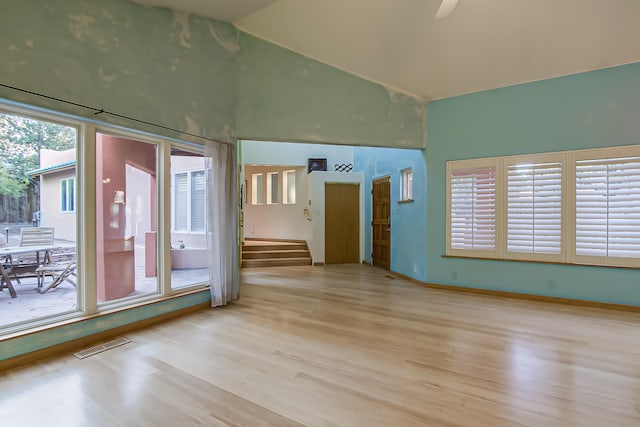 unfurnished room featuring light hardwood / wood-style floors and vaulted ceiling