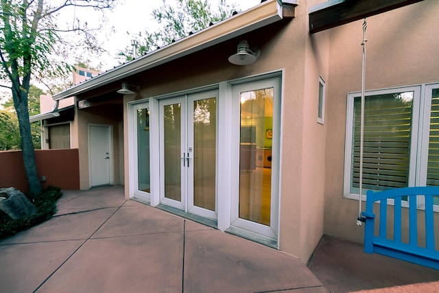 view of exterior entry with a patio and french doors