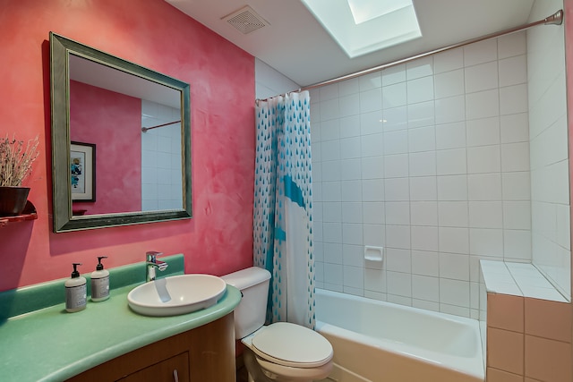 full bathroom featuring shower / bath combination with curtain, vanity, a skylight, and toilet