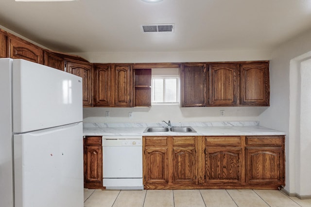 kitchen featuring white appliances, sink, and light tile patterned floors