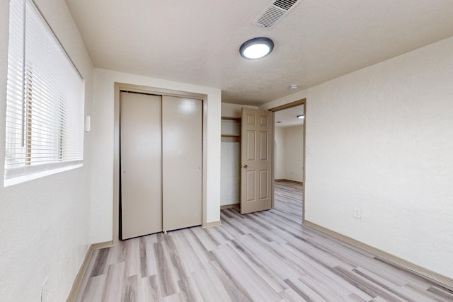 unfurnished bedroom featuring light hardwood / wood-style floors and a closet