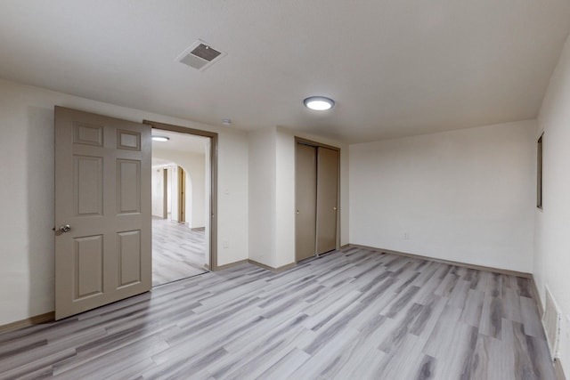 unfurnished bedroom with a closet and light hardwood / wood-style flooring