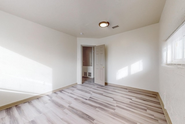 empty room with light hardwood / wood-style flooring