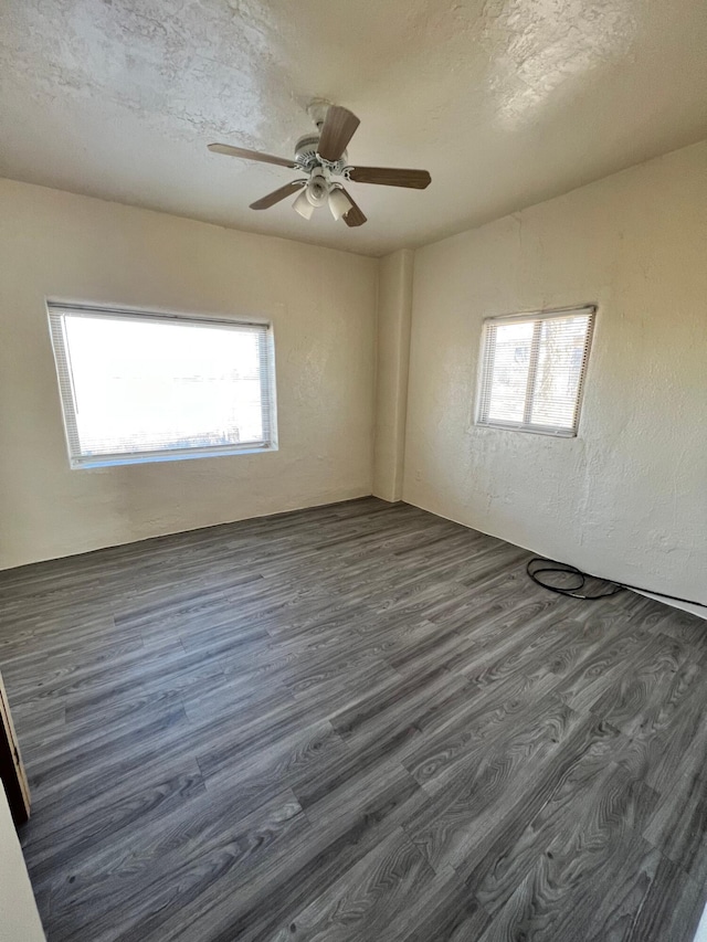 spare room featuring a textured ceiling, ceiling fan, and dark wood-type flooring