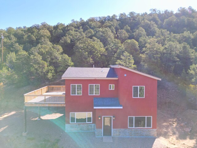 7 Shasta Ct, Cedar Crest, NM 87008 - rear view of house with a deck, a wooded view, stone siding, and stucco siding