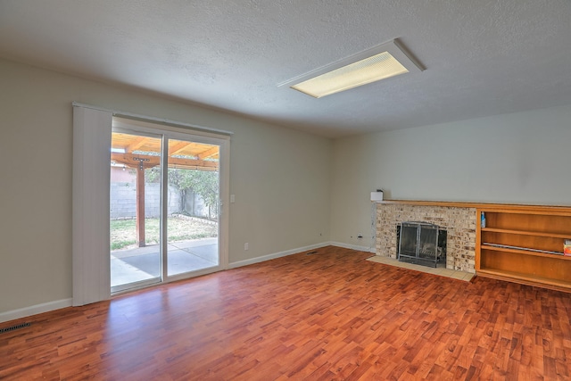 unfurnished living room with a fireplace, a textured ceiling, and hardwood / wood-style floors