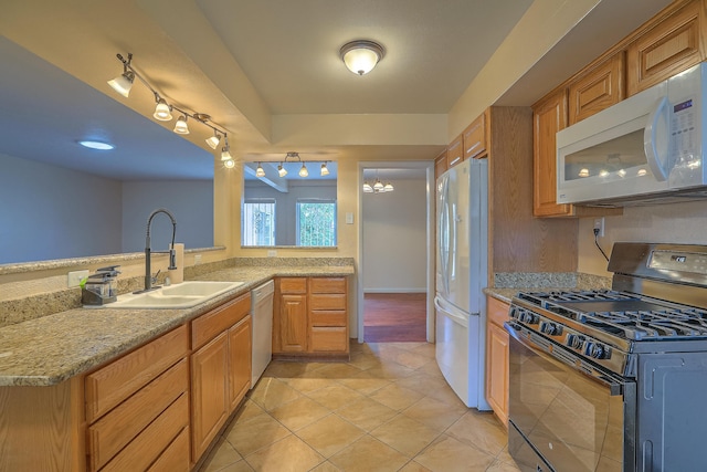 kitchen featuring sink, white appliances, light tile patterned floors, kitchen peninsula, and a notable chandelier