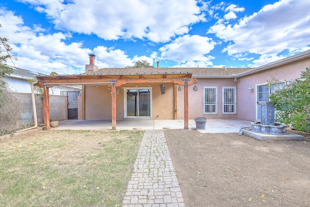 back of house with a patio and a lawn