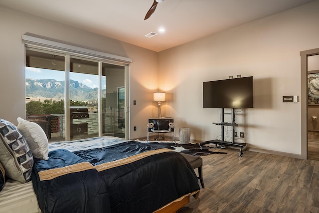 bedroom featuring ceiling fan, a mountain view, hardwood / wood-style floors, and access to exterior