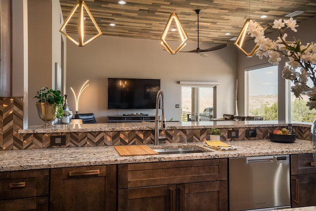 kitchen featuring backsplash, sink, stainless steel dishwasher, and light stone counters