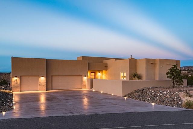 pueblo-style home with a garage