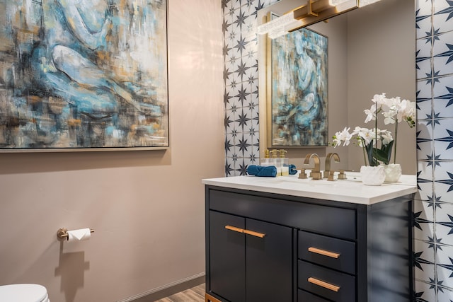 bathroom with vanity, hardwood / wood-style flooring, and toilet