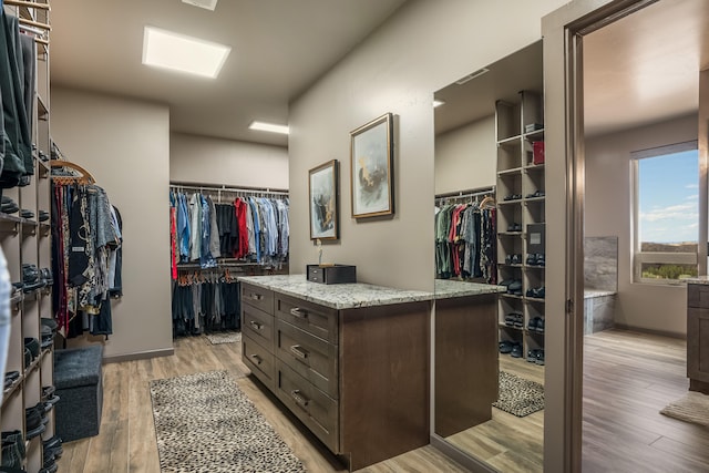 walk in closet with light wood-type flooring