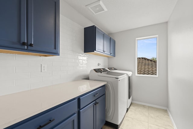 washroom featuring cabinets, independent washer and dryer, a textured ceiling, and light tile patterned flooring