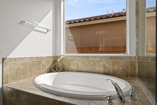 bathroom with tiled tub and plenty of natural light