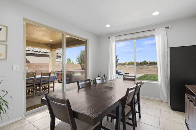 dining area featuring a textured ceiling and light tile patterned floors