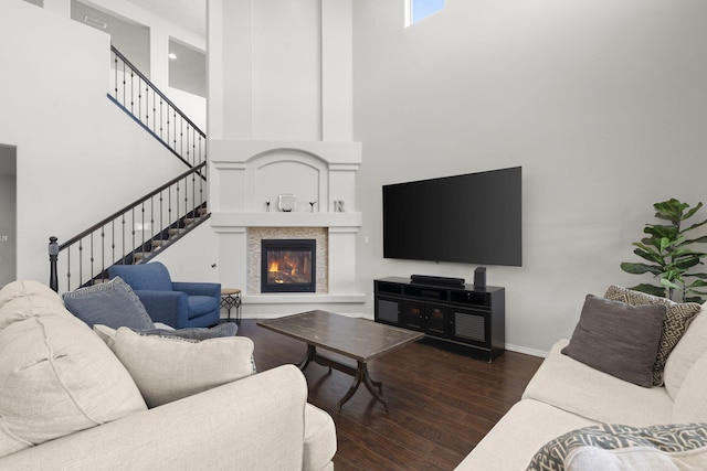 living room featuring a high ceiling and dark hardwood / wood-style flooring