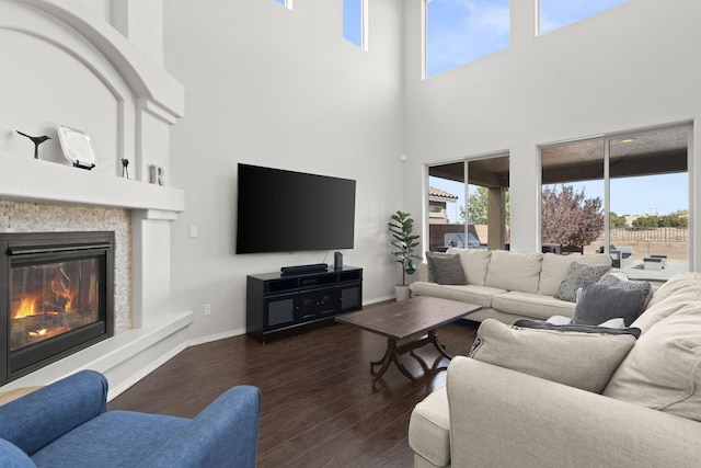 living room with dark hardwood / wood-style floors and a towering ceiling