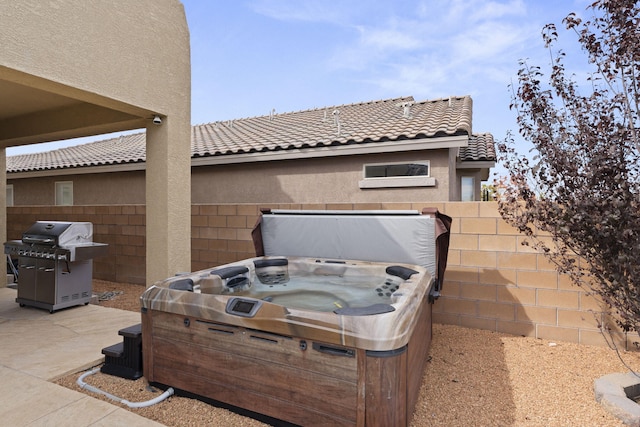 view of patio featuring a hot tub and a grill