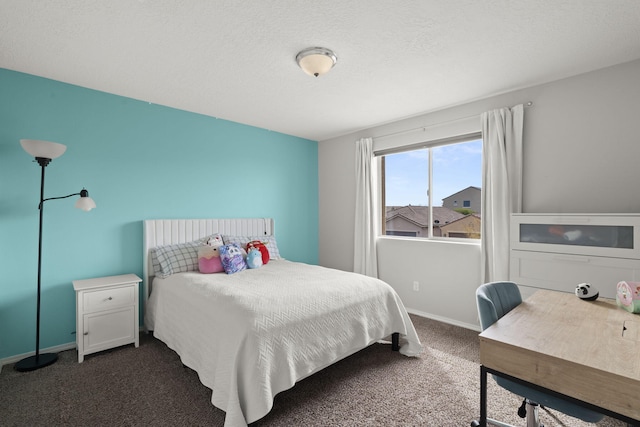 bedroom with a textured ceiling and dark carpet