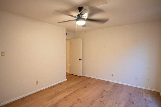 empty room featuring ceiling fan, light hardwood / wood-style floors, and a textured ceiling