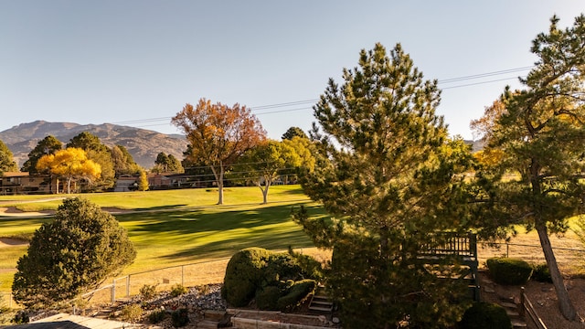 surrounding community with a mountain view and a yard