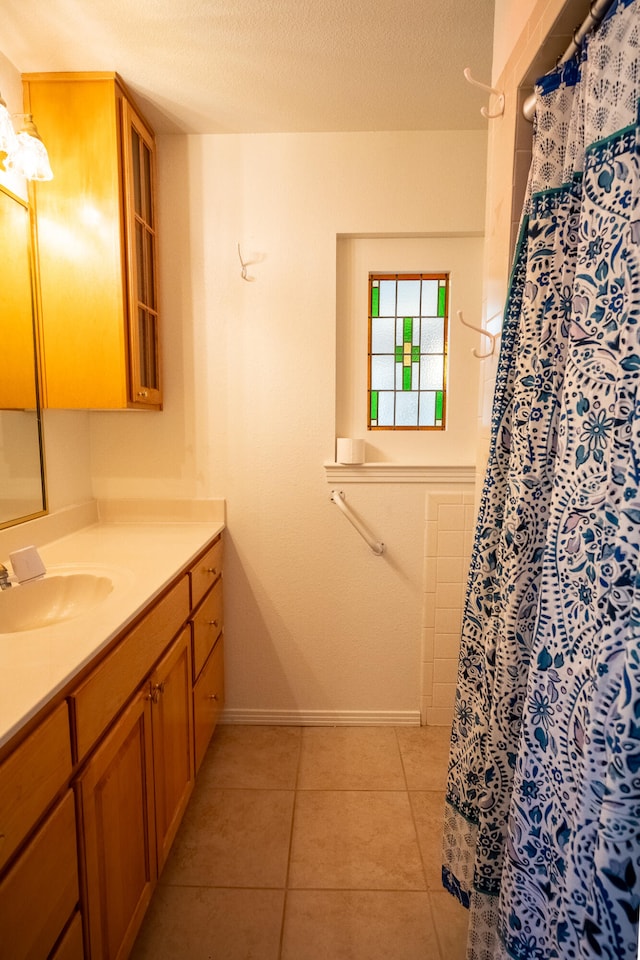 bathroom with tile patterned flooring, a textured ceiling, and vanity