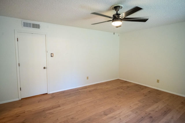 spare room featuring a textured ceiling, light hardwood / wood-style flooring, and ceiling fan