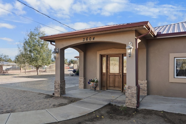 property entrance featuring stucco siding and stone siding