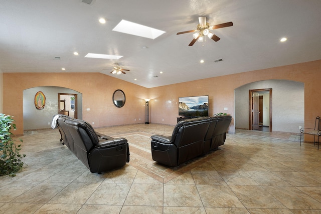 living room with ceiling fan and lofted ceiling with skylight