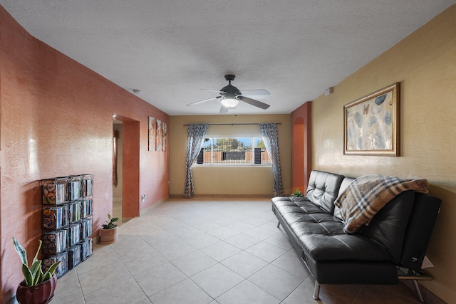 tiled living room featuring ceiling fan and a textured ceiling