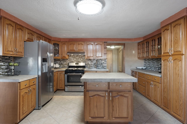 kitchen with backsplash, a center island, stainless steel appliances, and a textured ceiling