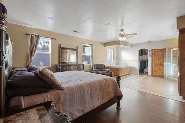 bedroom featuring ceiling fan, a textured ceiling, and light hardwood / wood-style flooring