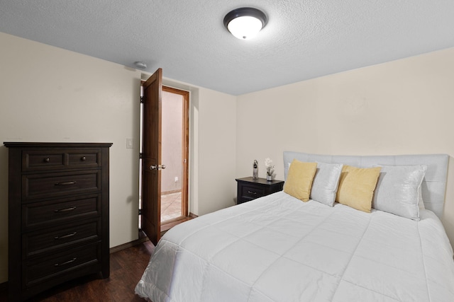 bedroom with dark hardwood / wood-style flooring and a textured ceiling