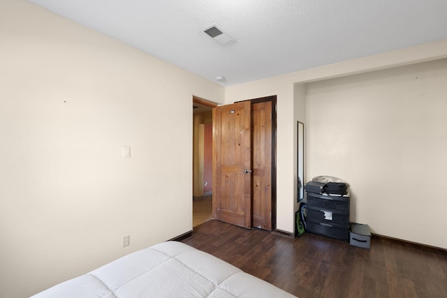 bedroom featuring a textured ceiling and dark hardwood / wood-style floors