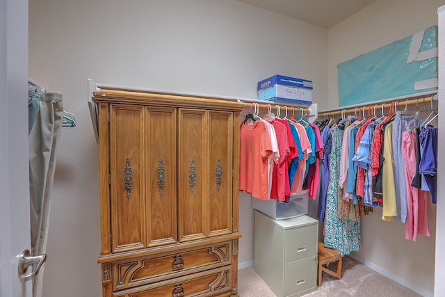 walk in closet featuring light colored carpet