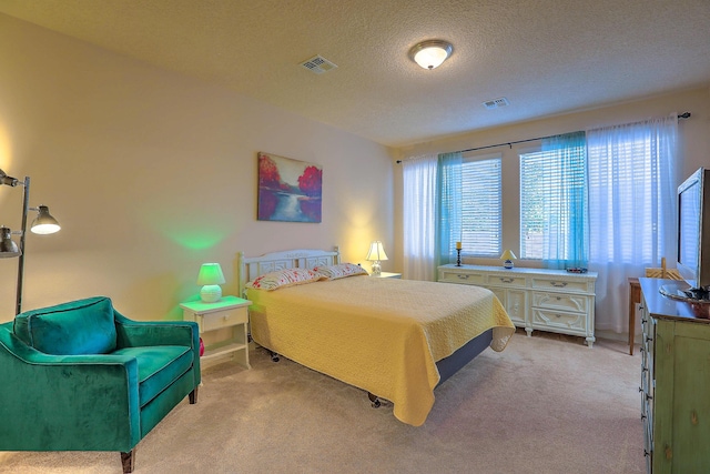 bedroom featuring a textured ceiling and light carpet