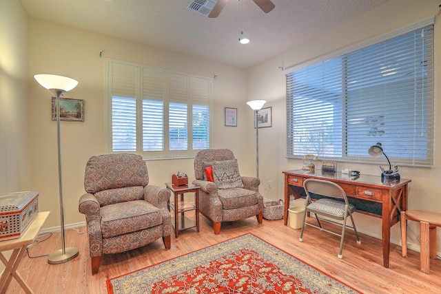 office area with ceiling fan, wood-type flooring, and a textured ceiling