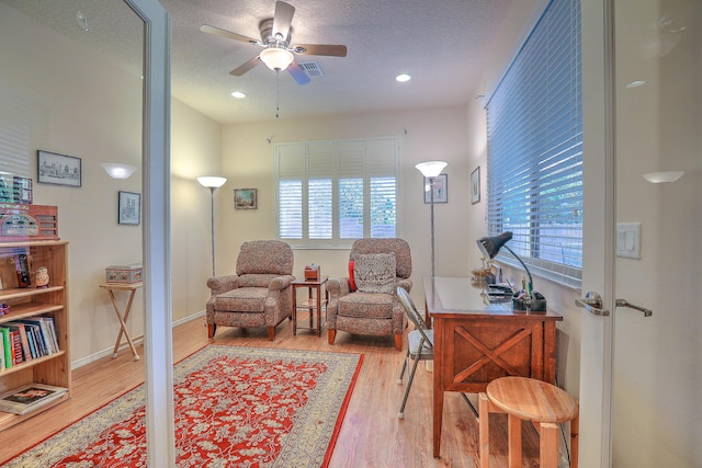 living area featuring plenty of natural light, hardwood / wood-style floors, and a textured ceiling