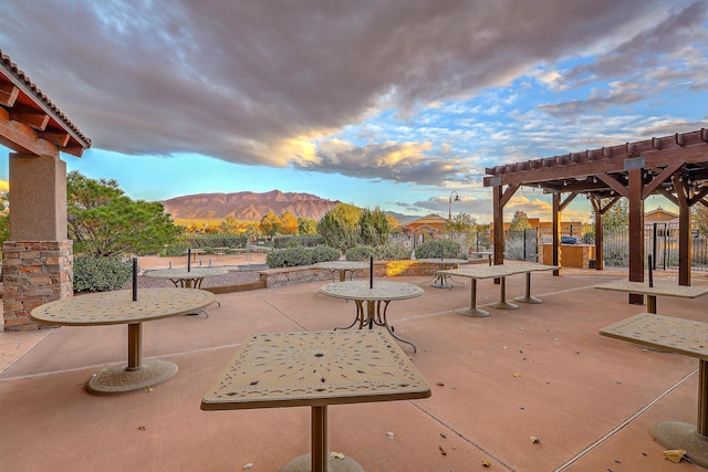 view of home's community with a pergola, a mountain view, and a patio