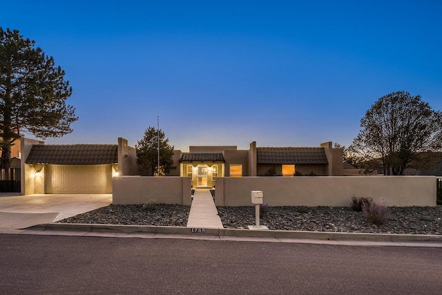 pueblo-style house featuring a garage